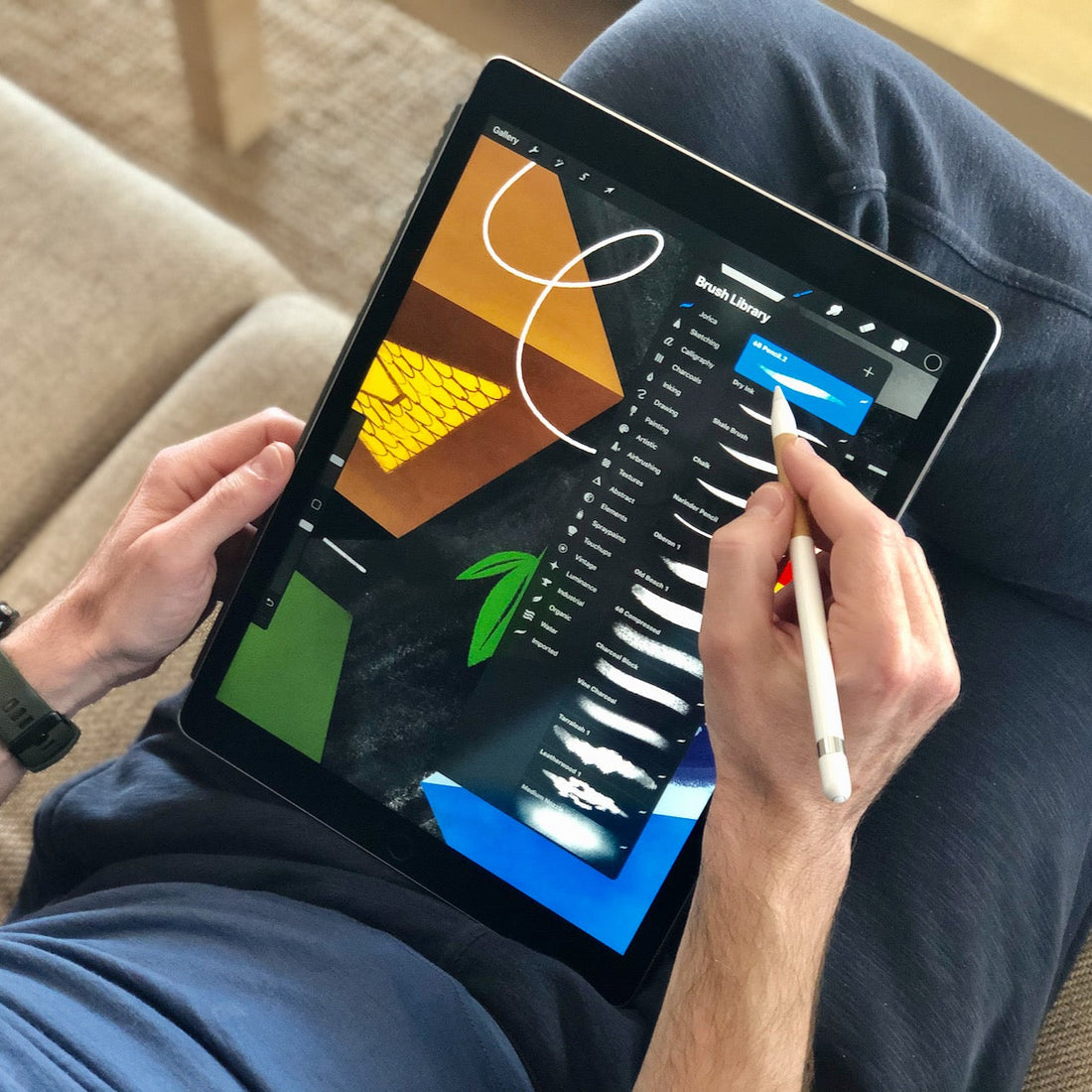 Ilustrator wybierający rodzaj pędzla w aplikacji Procreate na iPadzie Pro